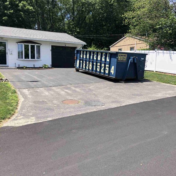 A Schiebel Waste dumpster in a residential driveway